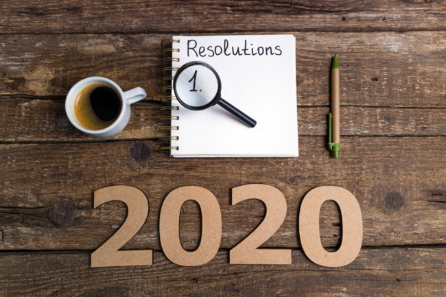 New year resolutions 2020 on desk. 2020 goals list with notebook